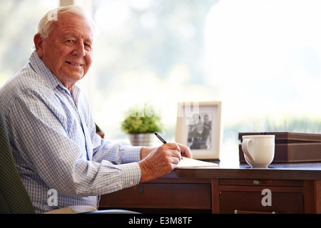 Man écrit mémoires En Book Sitting At Desk Banque D'Images