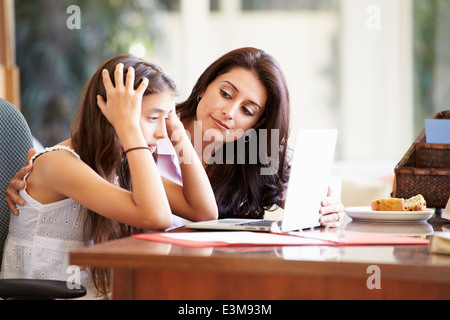 Mother Helping a souligné fille adolescente Looking At Laptop Banque D'Images