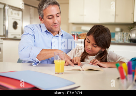 Père fille aider avec les devoirs à la table de lecture Banque D'Images