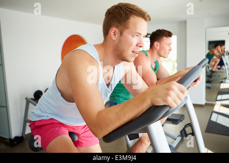Deux jeunes hommes en formation sur l'ensemble des machines de Sport cyclisme Banque D'Images