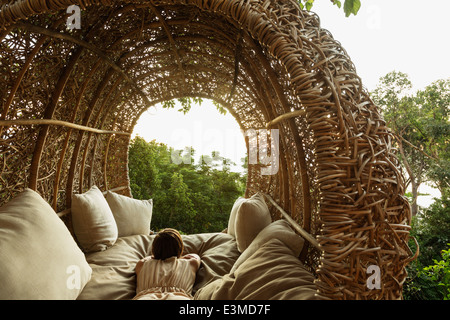 Woman laying in nest tree house Banque D'Images