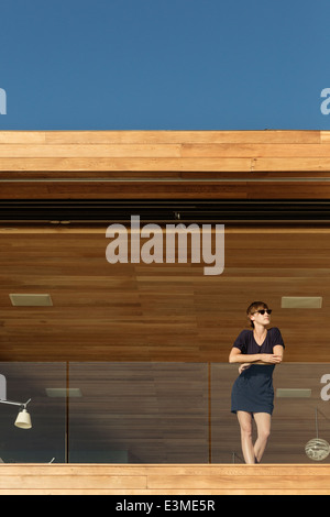 Femme debout sur le balcon de luxe Banque D'Images