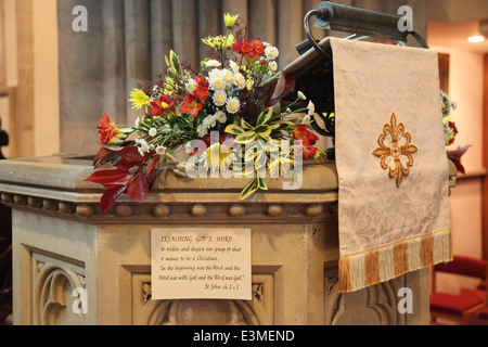 Fleurs et lecture de l'Évangile sur la chaire de l'église Banque D'Images