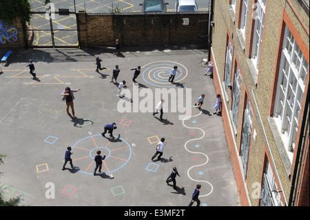 Les enfants jouant dans une cour d'école dans une école primaire de Londres. Banque D'Images
