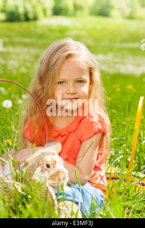 Petite fille avec lapin dans le panier Banque D'Images