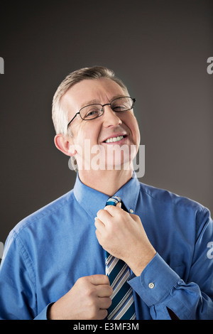 Portrait of businessman ajustant sa cravate Banque D'Images