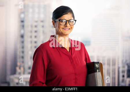 Portrait of smiling businesswoman in fenêtre urbaine Banque D'Images