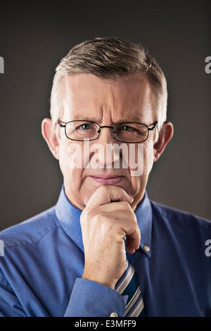 Portrait of smiling businessman with hand on chin Banque D'Images