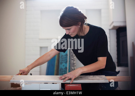 Female carpenter mesurer planche en bois Banque D'Images