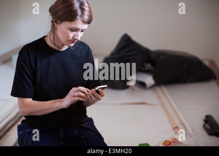 Female carpenter using mobile phone at site Banque D'Images