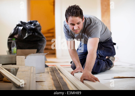 Male carpenter l'examen de planche en bois sur le site Banque D'Images