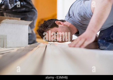 Male carpenter contrôle de planche en bois sur le site Banque D'Images