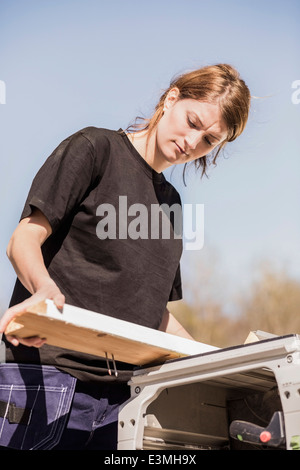 Low angle view of female carpenter working outdoors Banque D'Images