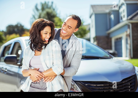 Heureux couple hugging in driveway Banque D'Images