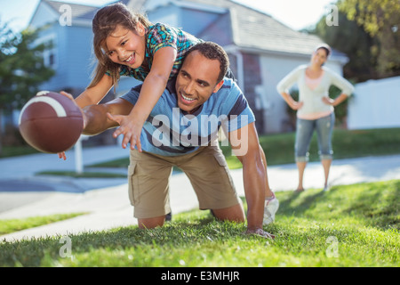 Père et fille jouant au football dans la cour Banque D'Images