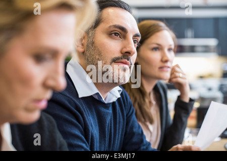 Concentrés businessman looking away in office meeting Banque D'Images