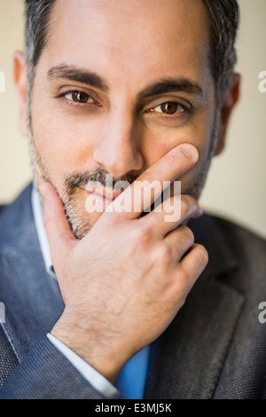 Portrait of smiling businessman with hand on face in office Banque D'Images