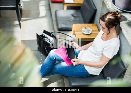 High angle view of mature woman using digital tablet in cafe Banque D'Images