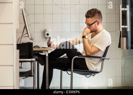 Side view of young businessman at computer desk in nouveau bureau Banque D'Images