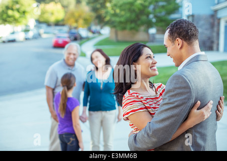 Couple hugging in driveway Banque D'Images