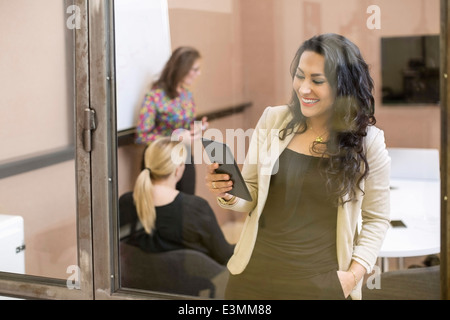 Happy businesswoman using digital tablet in creative office Banque D'Images