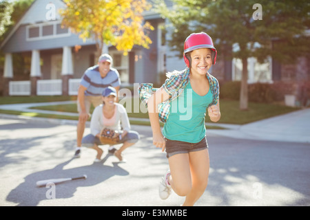 Famille jouer au baseball dans Street Banque D'Images