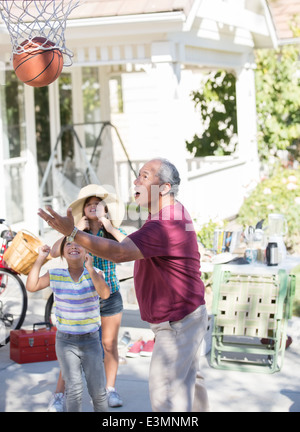 Grand-père et petites-filles jouant au basket-ball Banque D'Images