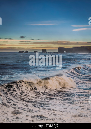 Vagues se brisant sur le rivage avec Dryholaey en arrière-plan, de l'Islande. Dyrholaey traduit signifie "la porte" de l'île de trou Banque D'Images