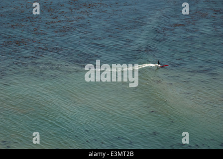 Lone surfer rides une douce houle d'été sur un longboard à Bluff Cove à Palos Verdes, près de Los Angeles, Californie, USA. Banque D'Images