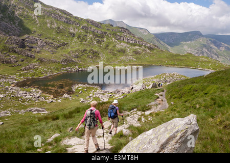 Marcheurs sur le chemin de Bwlch Tryfan à Llyn Bochlwyd et y Gribin en été dans les montagnes Snowdonia National Park North Wales Royaume-Uni Grande-Bretagne Banque D'Images