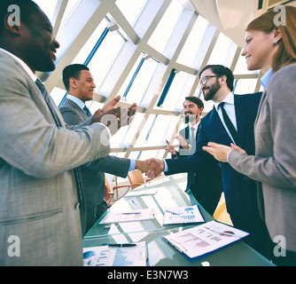 Groupe de gens d'affaires applaudissant leurs mains tandis que leurs collègues handshaking Banque D'Images