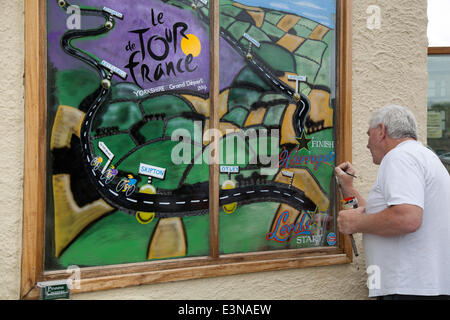 Artiste de fenêtre utilisant un mahlstick, ou maulstick dans le parc national de Skipton Yorkshire Dales, Royaume-Uni. Eddie Ralph, artiste local, complétant son tableau alors que Yorkshire se prépare pour le Tour de France, L'itinéraire d'art du vélo est décoré de vélos jaunes et de bannières tandis que les entreprises se mettent à l'avant pour la plus grande course cycliste du monde qui débutera dans le comté les 5 et 6 juillet 2014, amenant des millions de fans à la route du Yorkshire pour encourager les champions du sport. Ce sera la première fois que le Tour se rend dans le nord de l'Angleterre après avoir effectué auparavant seulement des visites sur la côte sud et la capitale. Banque D'Images