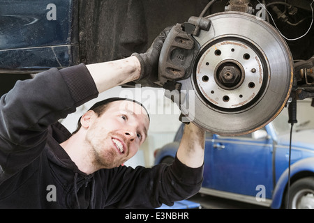 Smiling travailleur homme la réparation de voiture en atelier de réparation automobile Banque D'Images