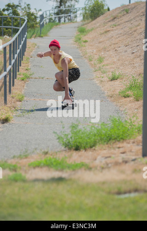 La longueur totale de l'homme skateboarding sur sentier Banque D'Images