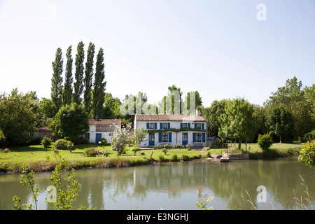 Près de Coulon (Deux-Sèvres - France), un très joli cottage par la Sèvre Niortaise river : la maison aux volets bleus. Banque D'Images