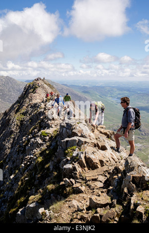 Voir l'arrière le long de Crib Goch ridge scramble auprès des randonneurs et des mains au démarrage de Snowdon Horseshoe en montagnes de Snowdonia National Park (Eryri) Wales UK Banque D'Images