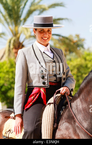 Femme de rider à sommet plat traditionnel hat assis sur son cheval en souriant lors de la Feria del Caballon. Banque D'Images