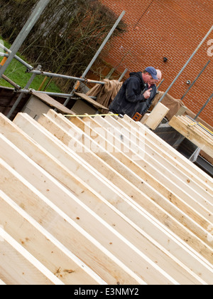 Construction maison, constructeur auto contrôle de positions fermes, avec client sur des échafaudages Banque D'Images