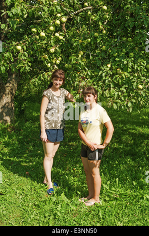 L'été 2013 vie rurale. Habitants du village - filles près d'un pommier. Banque D'Images