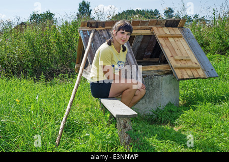 L'été 2013 vie rurale. Habitants du village - la jeune fille près d'un puits. Banque D'Images