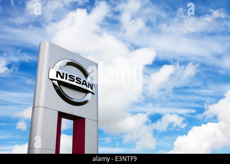 Garage voiture Nissan logo emblème inscription espace copie icône contre ciel dramatique décalage à gauche Banque D'Images