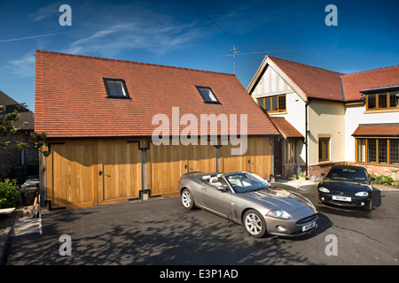 La construction de maisons, nouvelle maison construite avec Jaguar XK et Mazda MX5 voiture garée sur le tarmac nouvellement posées dur Banque D'Images