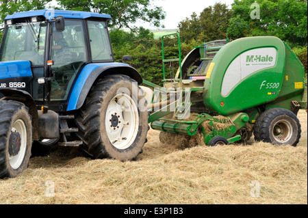 Machine de traction du tracteur, presse à balles, pour faire de grandes boites rondes de couper de l'herbe pour le foin ou l'ensilage Banque D'Images