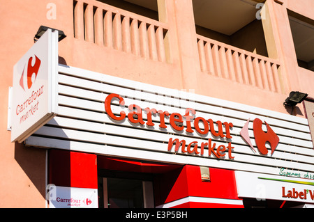 Les panneaux rouge et blanc avec logo à l'extérieur de l'entrée d'un magasin Carrefour, une chaîne de supermarchés français bien connu. Banque D'Images