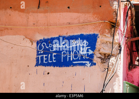 Inscription peinte à la main en arabe et en français pour un téléphone 'Téléphone' dans le souk de Marrakech, Maroc Banque D'Images