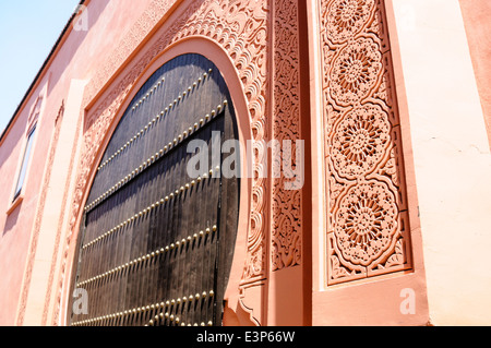 Pierre sculptée ornée autour de la porte d'un bâtiment à Marrakech, Maroc Banque D'Images