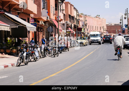 Rue typique de Marrakech, Maroc avec les scooters en stationnement voitures et cars. Banque D'Images