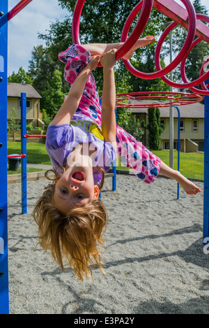 Jeune fille sur l'aire de jeux de bars. Banque D'Images