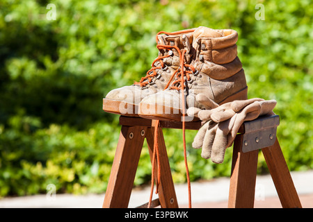 Des bottes et des gants de travail sur un escabeau Banque D'Images