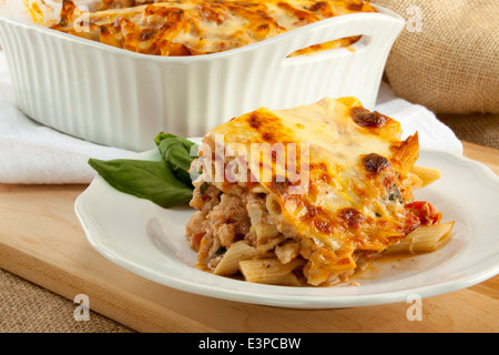 Ziti cuit italien servant sur la plaque avec un cocotte en arrière-plan. Fourche de morsure sur elle. Ressemble à des lasagnes Banque D'Images